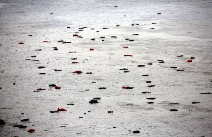 845321-life-vests-and-tubes-left-by-migrants-float-by-a-beach-during-a-rain-storm-on-the-greek-island-of-le